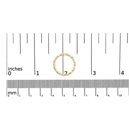Top-down view of a yellow ring with round white gemstones in a channel setting, placed on a ruler for size reference.
