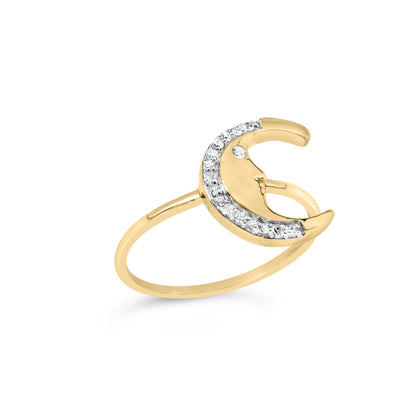 Yellow metal ring with crescent moon design featuring round white gemstones in prong setting along the curve and one gemstone as the moon's eye, shown at an angled side view.