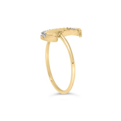 Side angle view of a yellow metal ring with a curved top section adorned with white round gemstones in prong settings.