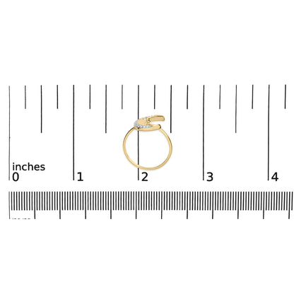 Top-down view of a yellow ring with round white gemstones in prong settings along the open curved band, placed on a ruler for size reference.