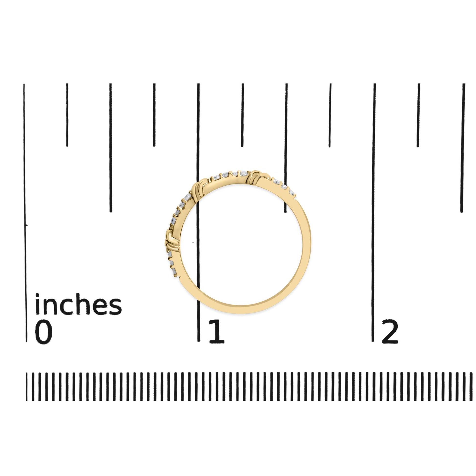 Yellow metal ring with round white gemstones in prong settings, shown flat on a scale from a top-down angle.