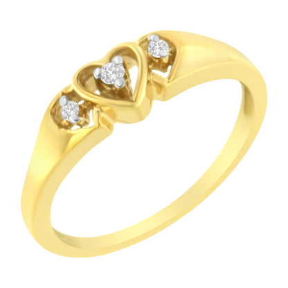 Yellow metal ring with three heart-shaped designs each holding a round white gemstone, shown from an angled close-up view.