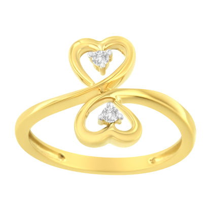 Yellow metal ring with two heart-shaped loops each holding a round prong-set brownish gemstone, shown in a front angled close-up.