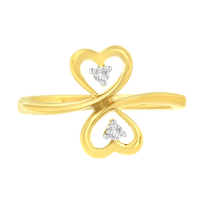 Yellow metal ring viewed from the front with two heart shapes facing opposite directions, each containing a brownish round gemstone in prong setting.