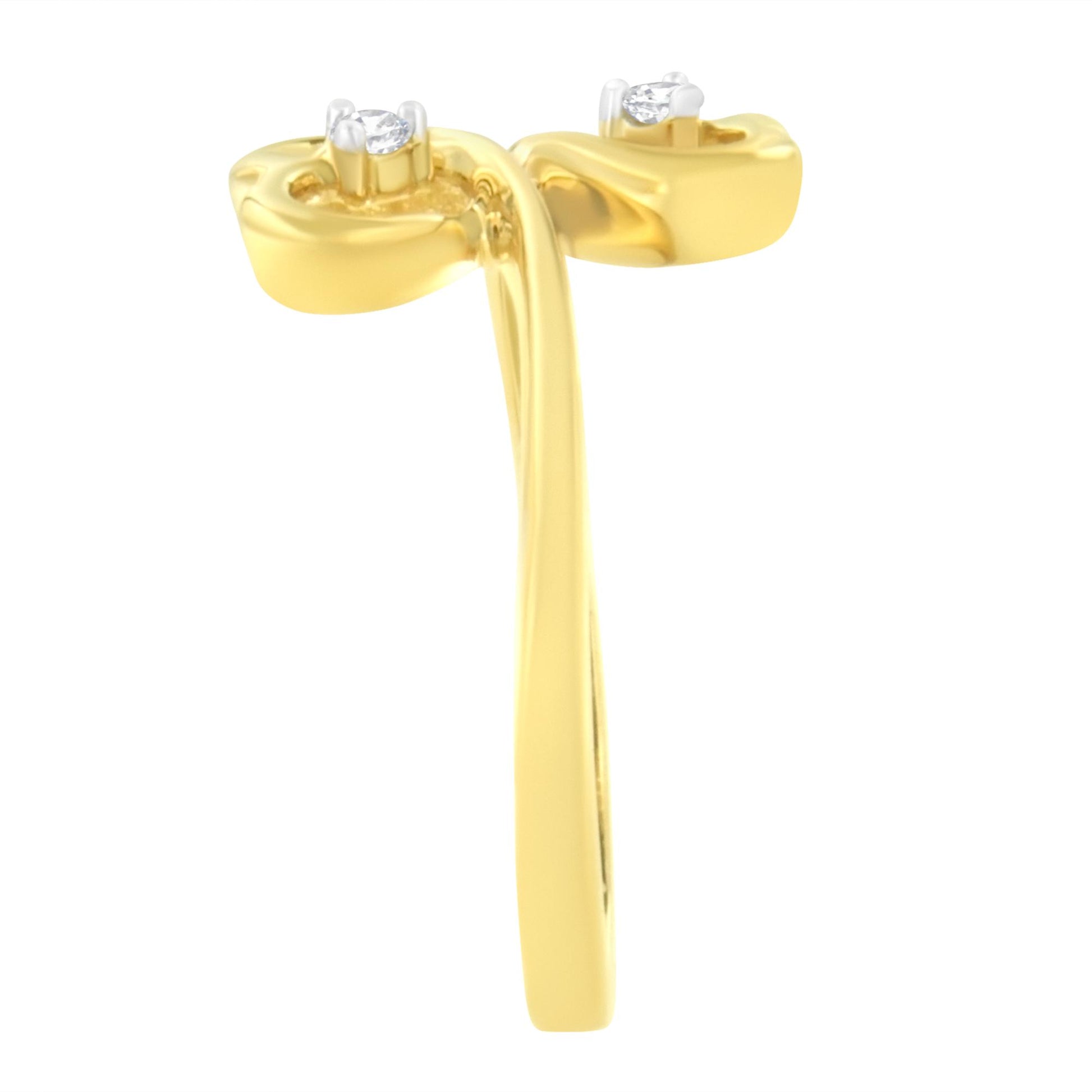 Close-up side view of a yellow ring with two round white gemstones in prong settings.