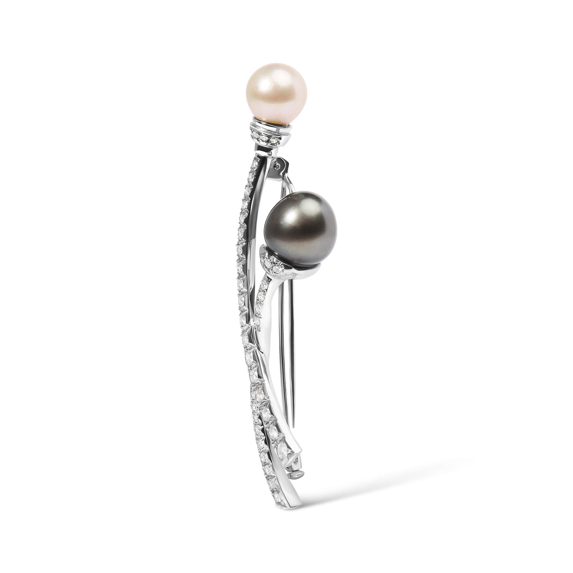Side view of a white metal brooch with two pearls, one white and one dark, each accented with small white gemstones along curved metal stems.