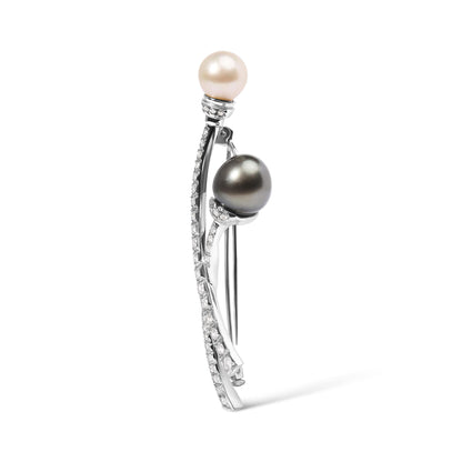Side view of a white metal brooch with two pearls, one white and one dark, each accented with small white gemstones along curved metal stems.