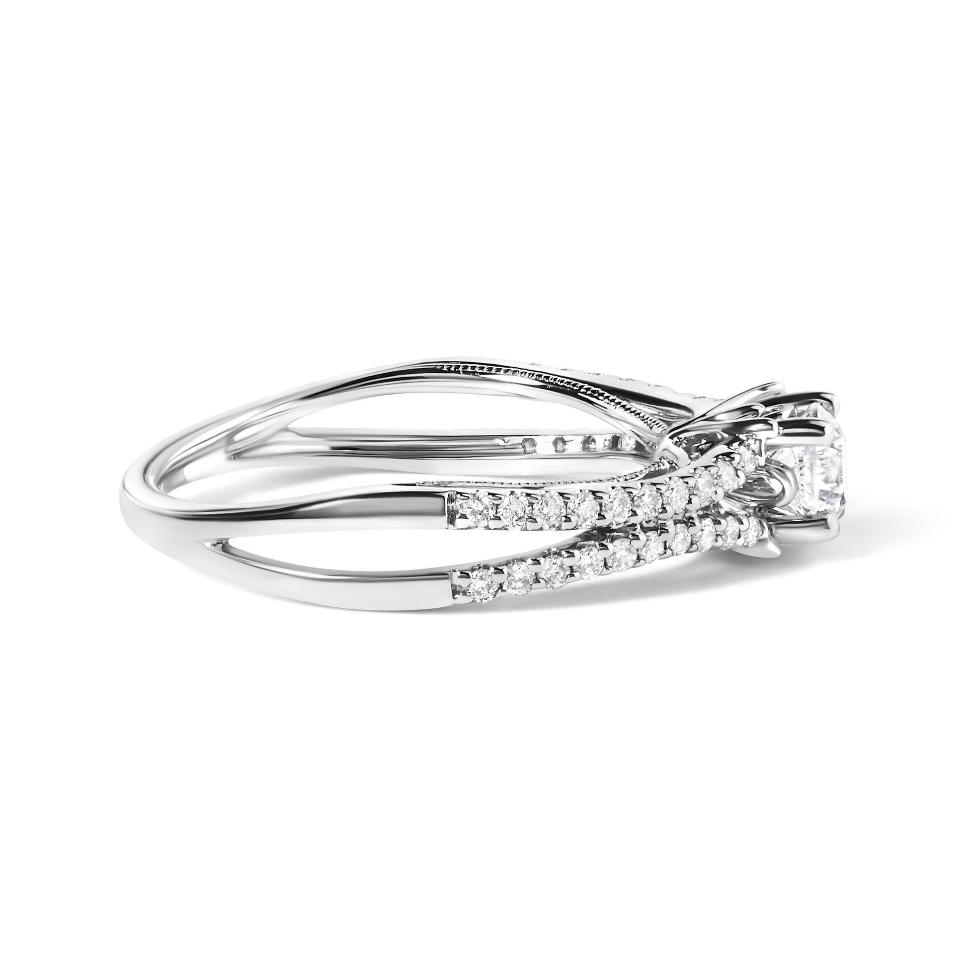 Side angled view of a white metal ring with a single round gemstone in a four-prong setting and multiple smaller round gemstones in a shared prong setting along the band.