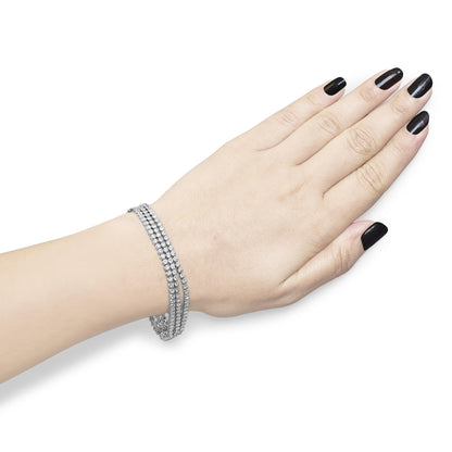 White metal triple-row bracelet with multiple round white gemstones in prong settings, shown on a model's wrist from a top angle.