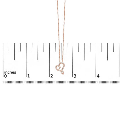 Rose and white metal heart-shaped necklace with round white gemstones in bezel setting, shown hanging against a ruler scale, front view.
