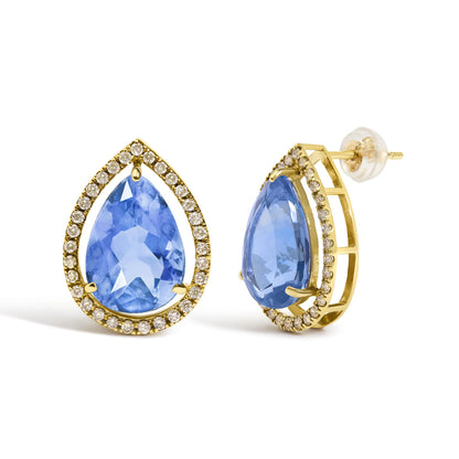 Close-up angled view of yellow metal earrings with pear-shaped blue gemstones surrounded by a halo of round white gemstones, shown against a white background.