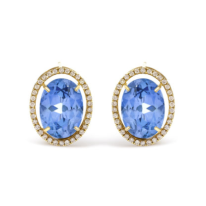 Close-up front view of yellow metal earrings featuring large oval blue gemstones surrounded by a halo of small round white gemstones in prong settings.