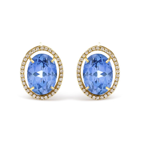 Close-up front view of yellow metal earrings featuring large oval blue gemstones surrounded by a halo of small round white gemstones in prong settings.