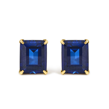 Close-up front view of a pair of yellow metal earrings featuring large rectangular blue gemstones in four-prong settings.