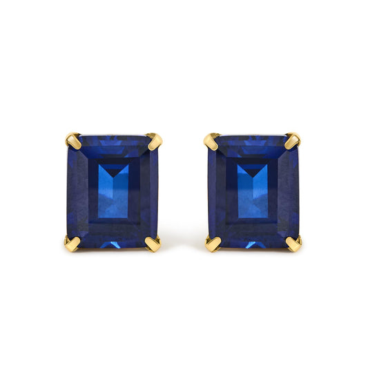 Close-up front view of a pair of yellow metal earrings featuring large rectangular blue gemstones in four-prong settings.