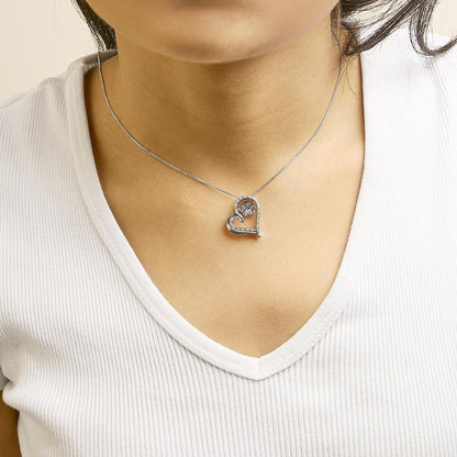 Necklace with a heart-shaped pendant featuring white gemstones, shown worn on a model from a front angle.
