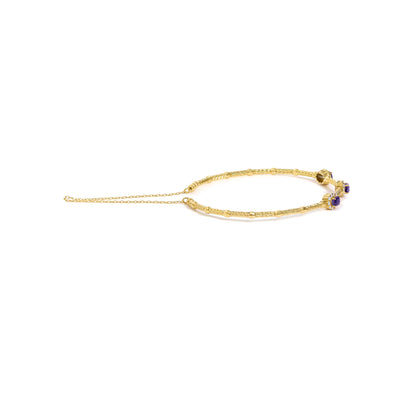 Yellow bracelet with textured and smooth sections, featuring clusters of oval purple gemstones surrounded by small round white gemstones in prong settings, shown flat on a white background from a top angle.