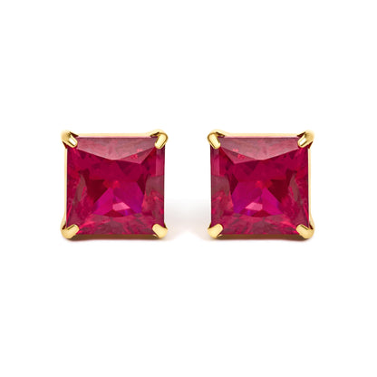 Close-up front view of yellow metal earrings featuring red princess-shaped gemstones in four-prong settings.