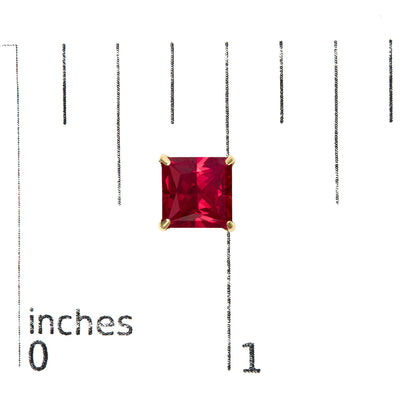 Close-up front view of yellow metal stud earring featuring a princess-shaped red gemstone in a 4-prong setting, shown on a scale.