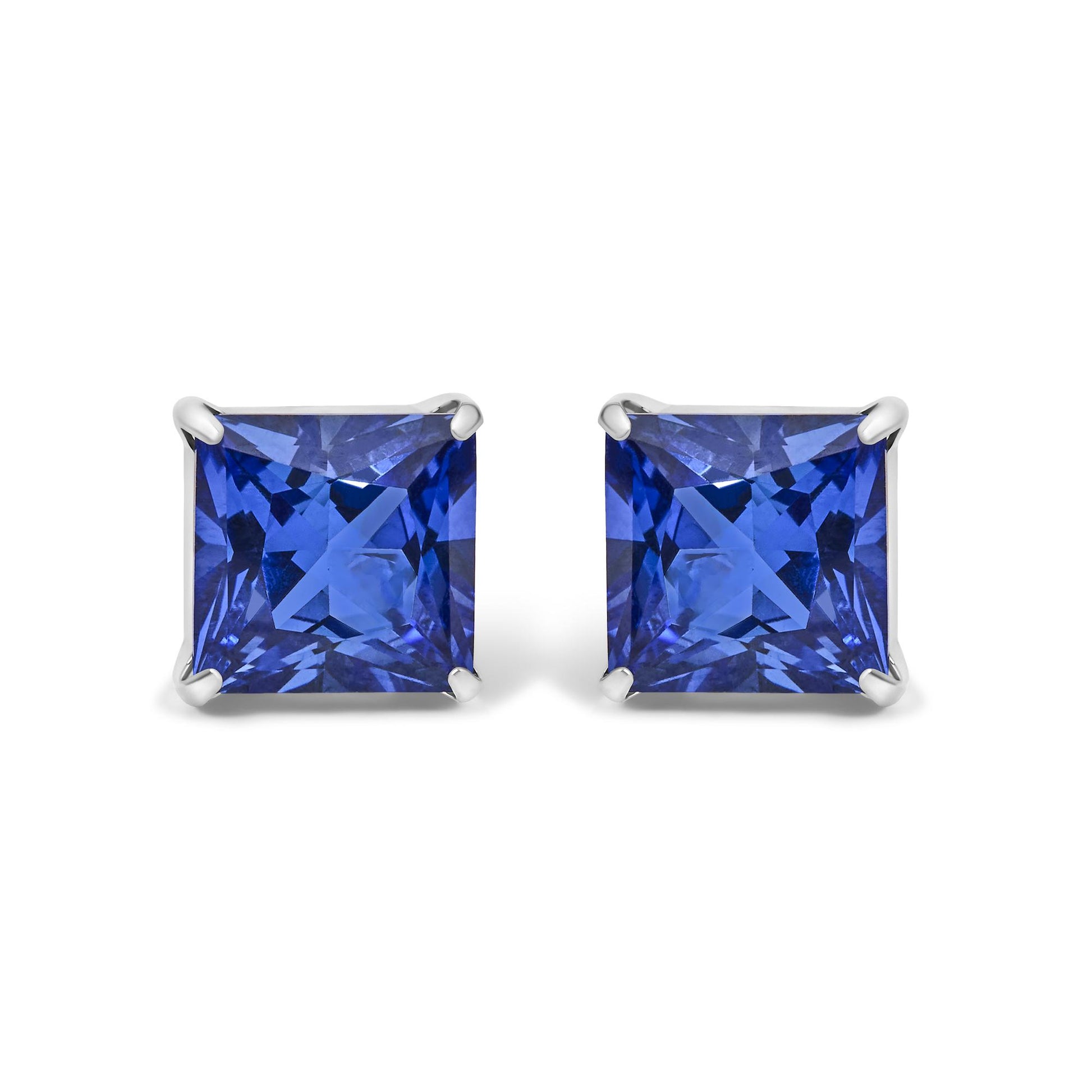 Pair of white metal earrings shown from the front with square-shaped blue gemstones in four-prong settings.