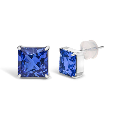 Close-up front and side angle of a pair of white metal stud earrings with princess-shaped blue gemstones in a four-prong setting.