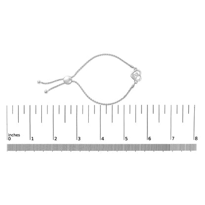 White metal bracelet with a heart-shaped charm set with white round gemstones, adjustable chain, shown on a ruler scale, top-down angle.