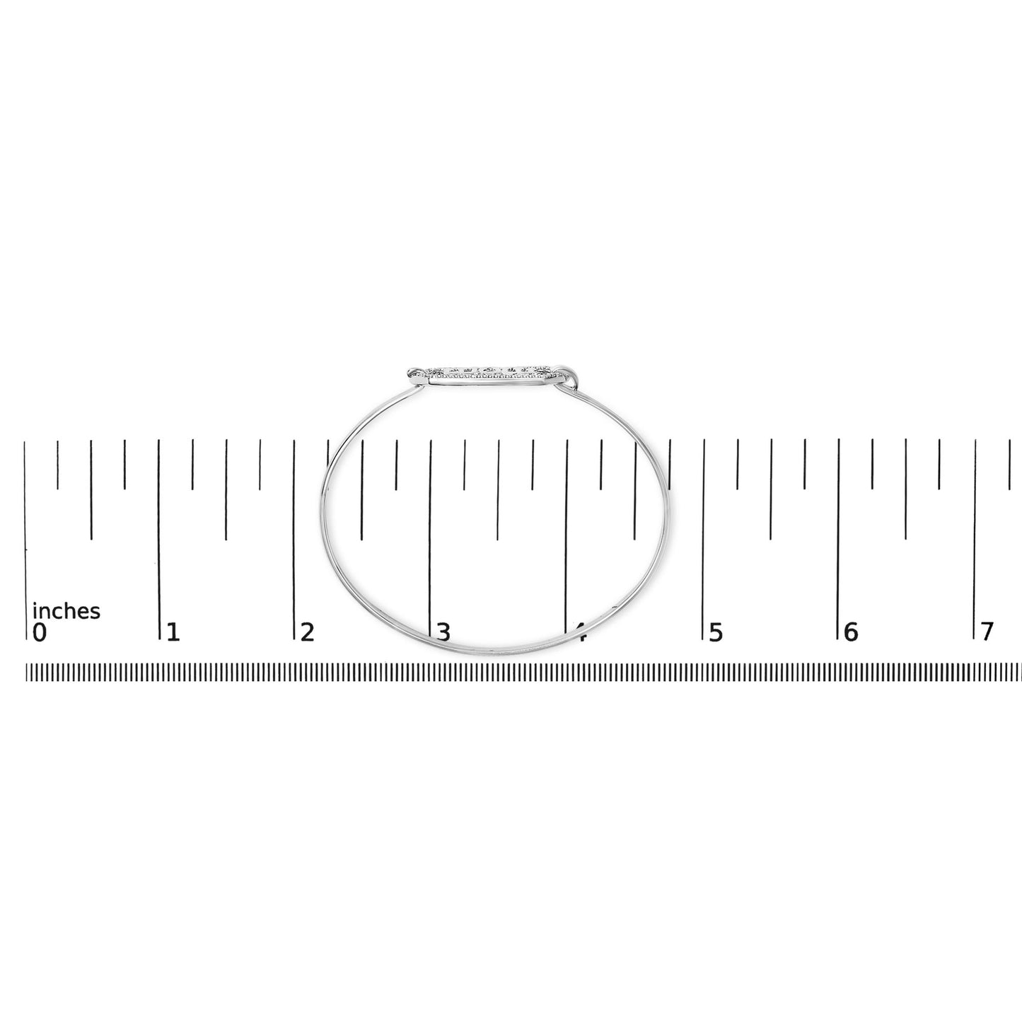 White metal bracelet with a horizontal oval centerpiece set with round white gemstones in prong settings, shown flat on a ruler for scale, photographed from above.