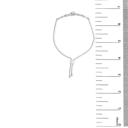 White metal bracelet with a central round white gemstone in 4-prong setting, surrounded by smaller round white gemstones in prong settings, adjustable sliding clasp, shown flat on a scale from above.