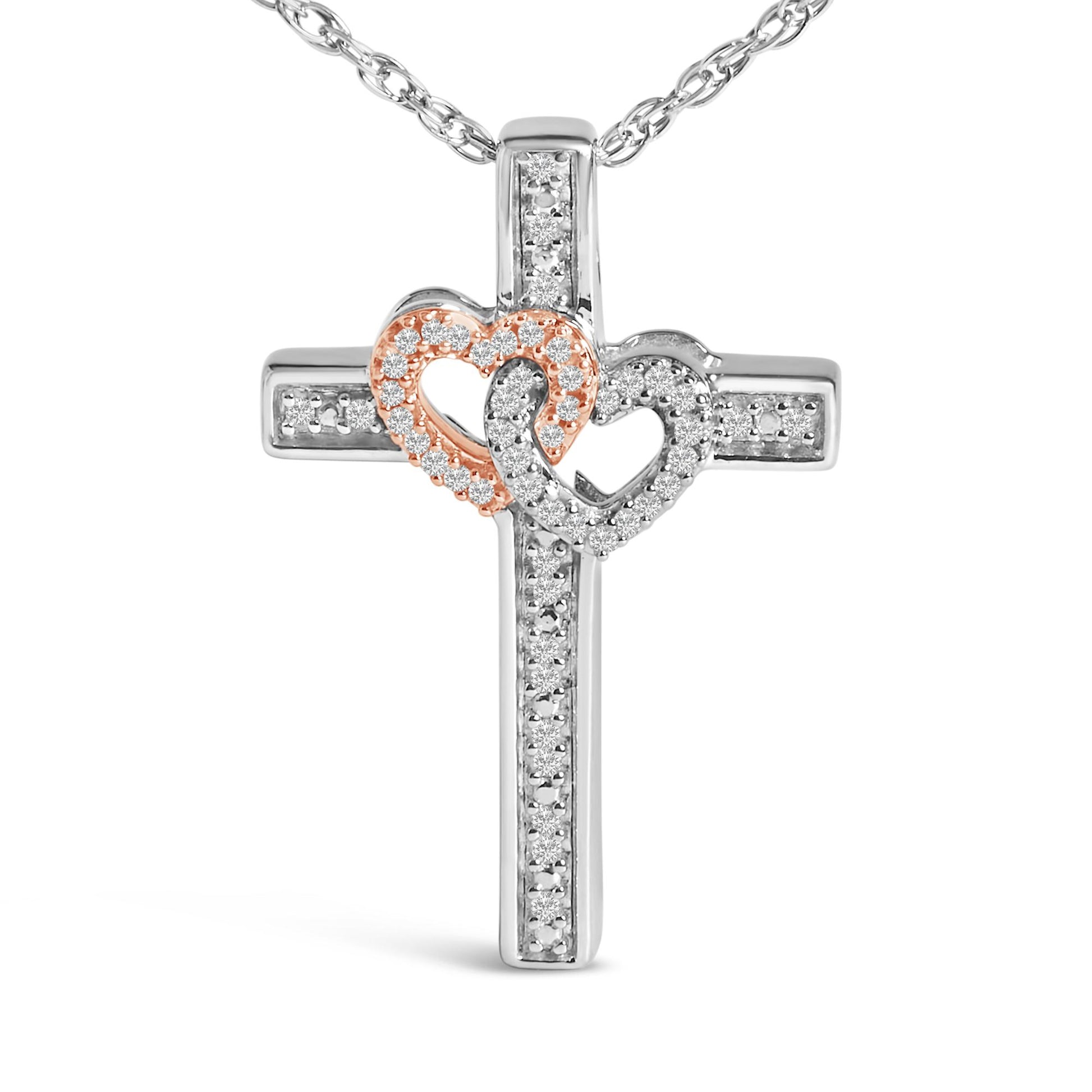 Close-up front view of a necklace pendant featuring a cross with two interlocking heart shapes adorned with white gemstones in a pave setting, one heart outlined in rose metal color and the other in white metal color.