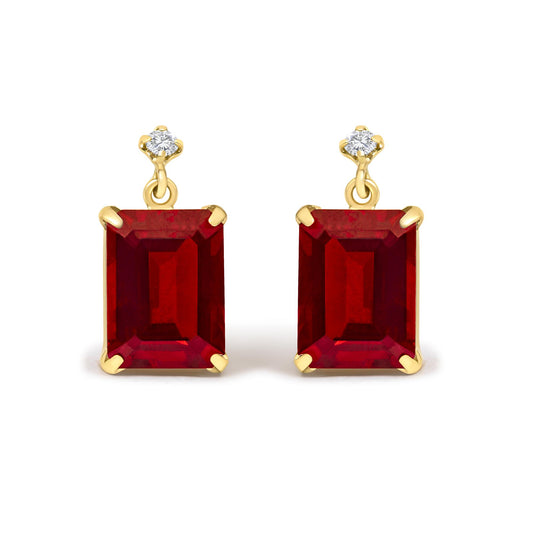 Close-up front view of yellow metal earrings with red emerald-shaped gemstones and white round gemstones held in 4-prong settings.