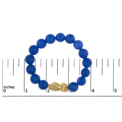 Yellow metal bracelet with round blue gemstone beads shown on a scale, top-down angle.