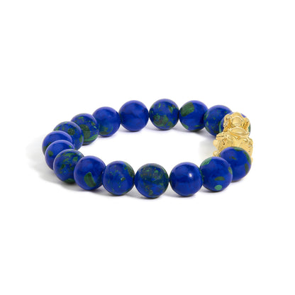 Close-up angle of a yellow metal bracelet featuring round blue and green gemstones strung together in a continuous loop.
