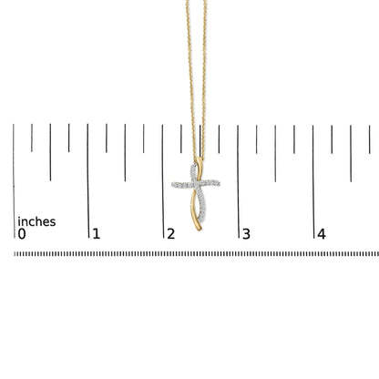 Necklace with a cross-shaped pendant featuring intertwined yellow and white metal strands, white round gemstones in prong setting on the white metal strand, shown hanging on a ruler scale, front view.