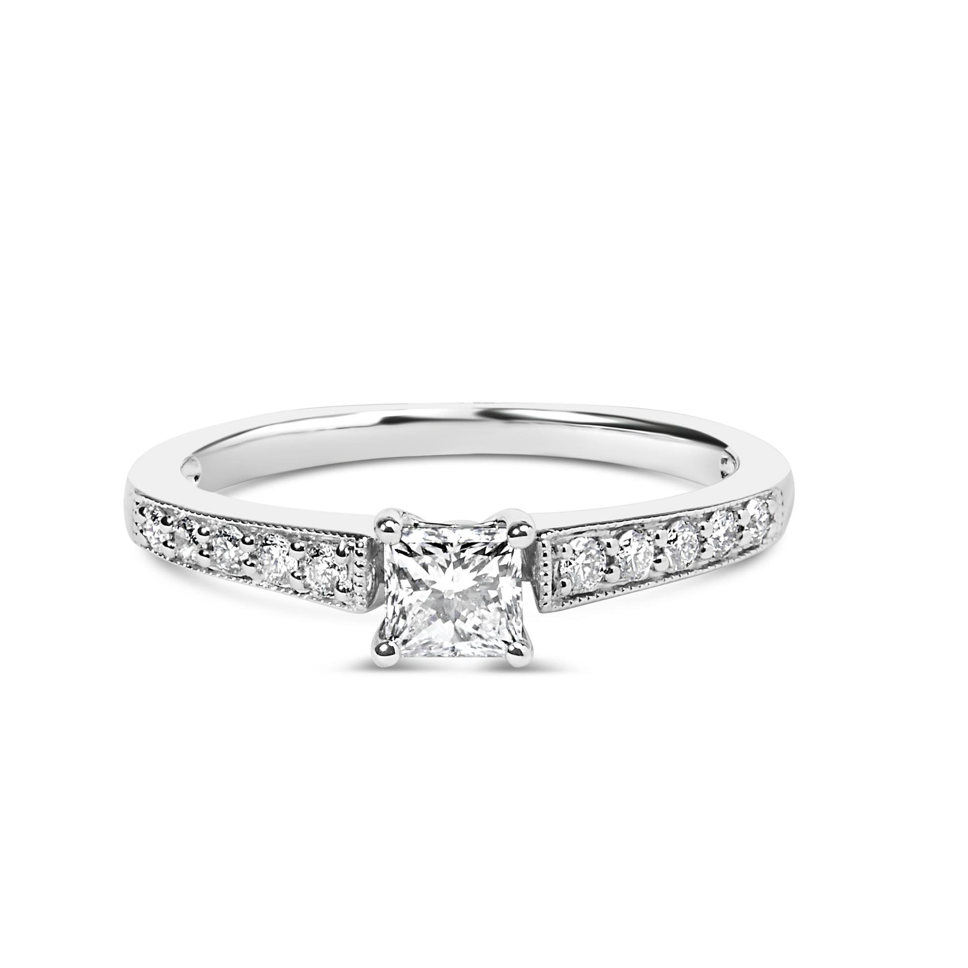White metal ring with a princess-shaped white gemstone in a four-prong setting at center, flanked by round white gemstones in shared prong settings along the band, shown from a front angle.