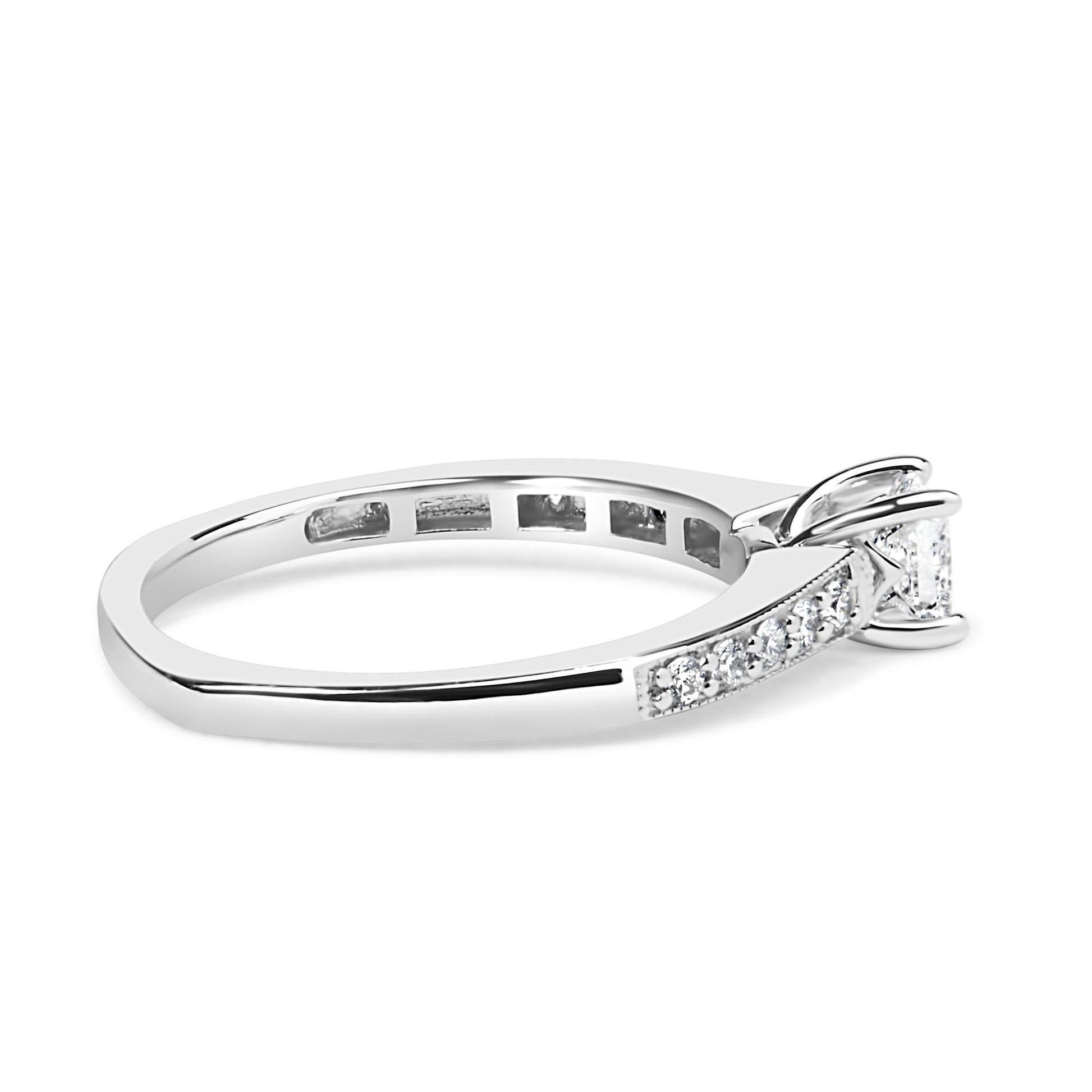 Side angle view of a white metal ring featuring a princess-shaped gemstone in a four-prong setting and multiple round gemstones in a shared prong setting along the band.