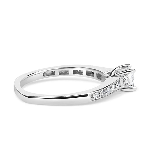 Side angle view of a white metal ring featuring a princess-shaped gemstone in a four-prong setting and multiple round gemstones in a shared prong setting along the band.