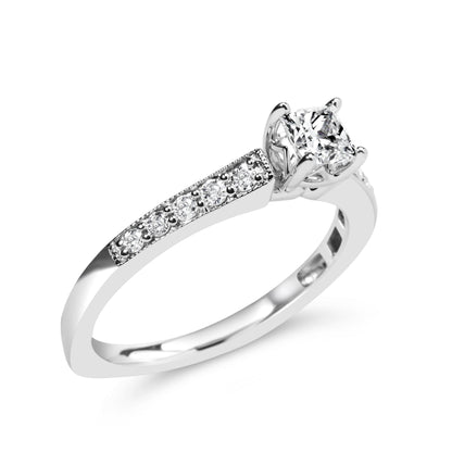 White metal ring with a princess-shaped white gemstone in a four-prong setting and round white gemstones in a shared prong setting along the band, shown at a slight angle.