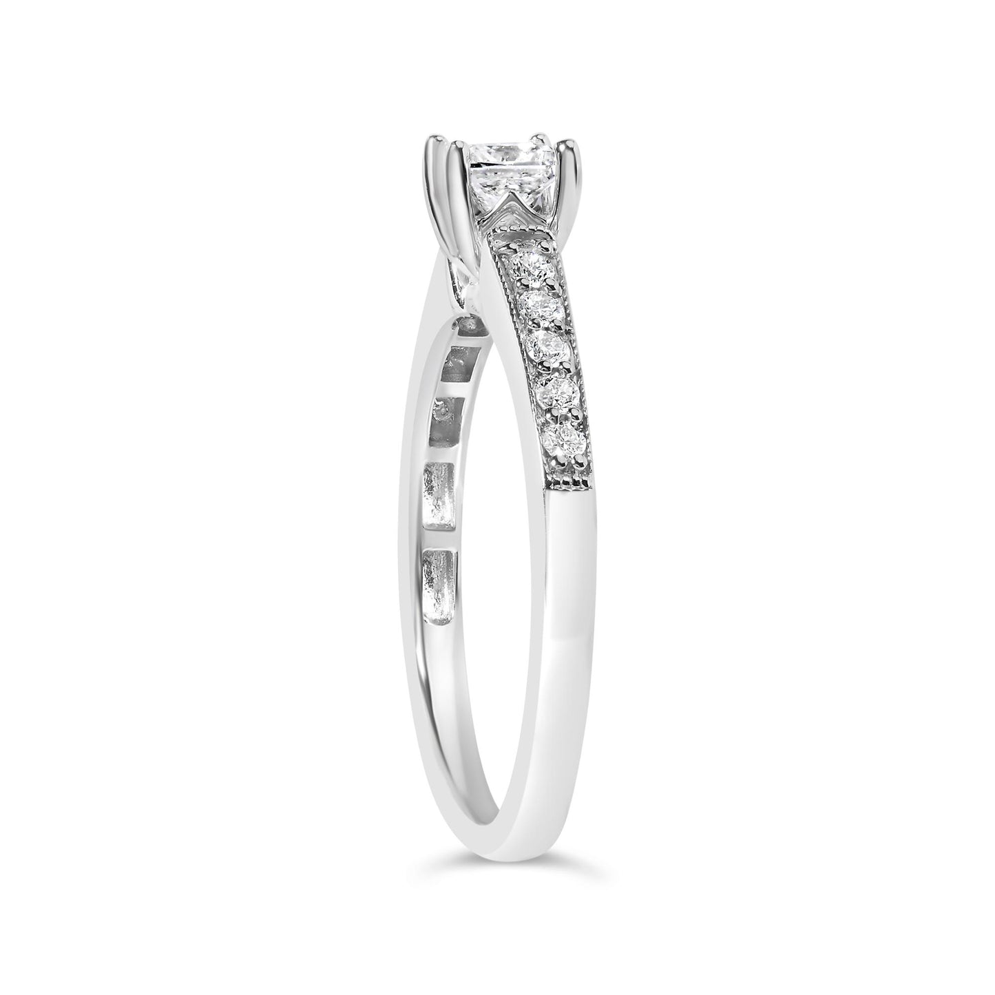 Side angle view of a white metal ring featuring a princess-shaped white gemstone in a 4-prong setting and multiple round white gemstones in a shared prong setting along the band.