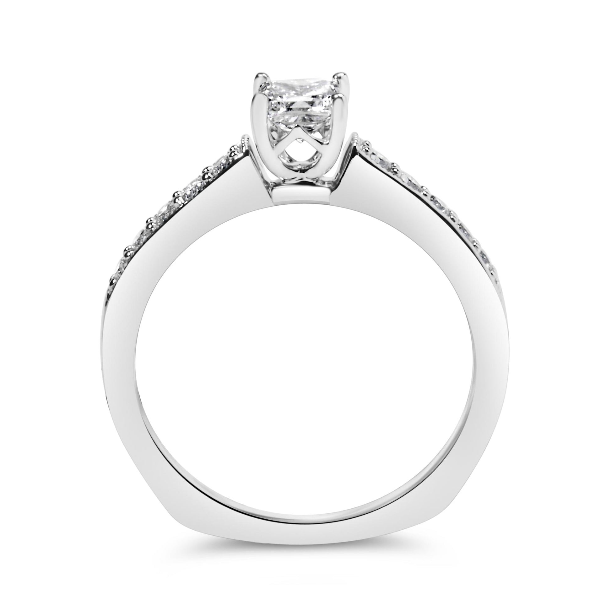 Side profile view of a white metal ring featuring a princess-shaped white gemstone in a 4-prong setting at the center and round white gemstones in a shared prong setting along the band.