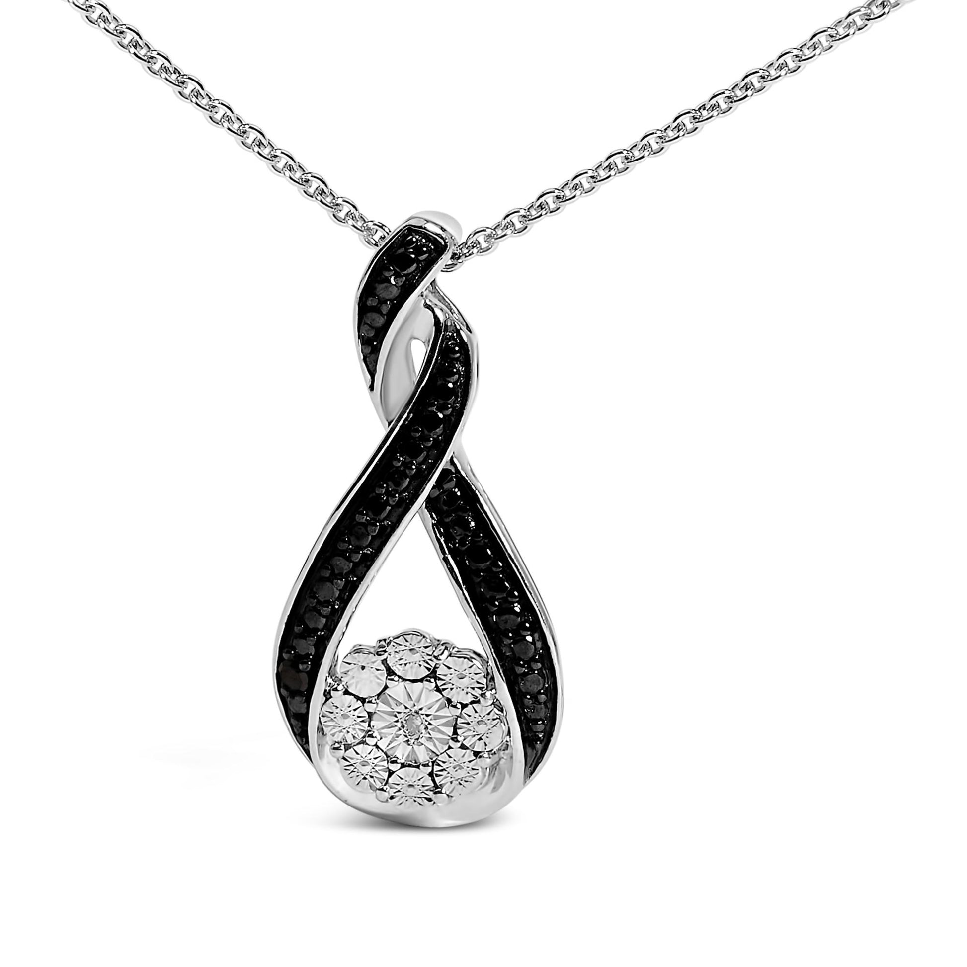 Close-up front view of a white and black metal necklace pendant with a twisting loop design featuring pave-set black gemstones on the loops and a cluster of white gemstones at the center bottom, shown on a chain.