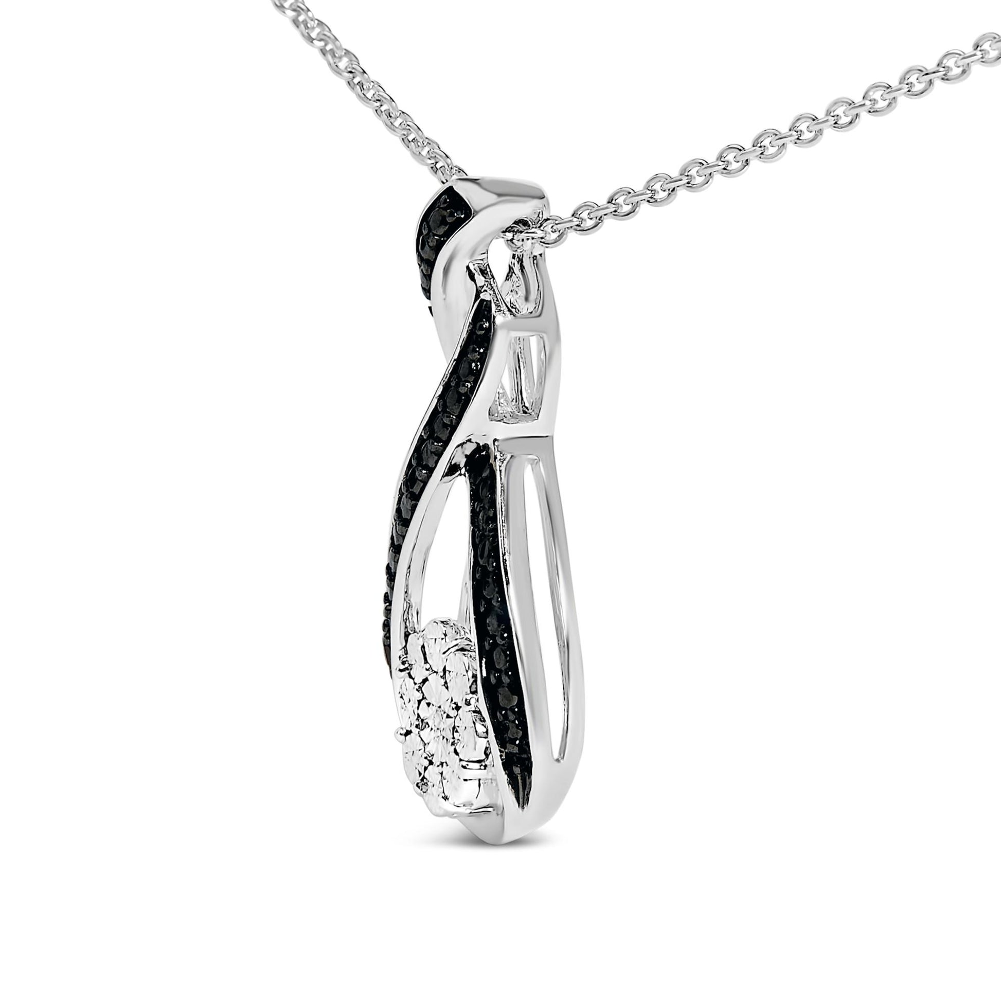 Close-up angled view of a white and black necklace pendant featuring a twisted design with black pave-set round gemstones and a cluster of white round gemstones, hanging on a white chain.