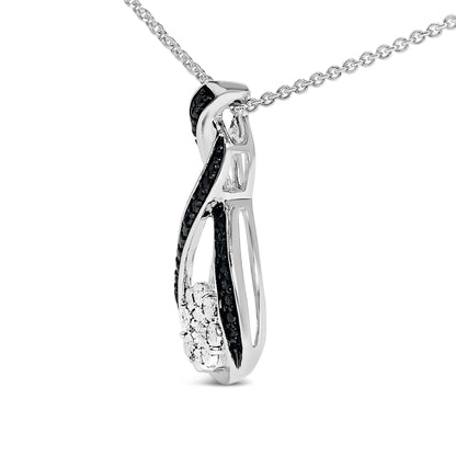 Close-up angled view of a white and black necklace pendant featuring a twisted design with black pave-set round gemstones and a cluster of white round gemstones, hanging on a white chain.