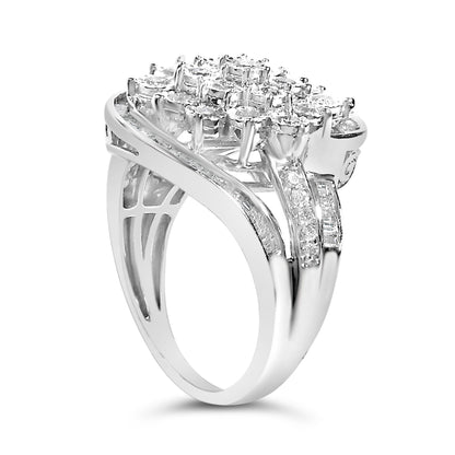 Close-up front angled view of a white metal ring featuring a cluster of round white gemstones set in prongs on top, with bands adorned by baguette and round white gemstones in channel and miracle settings.