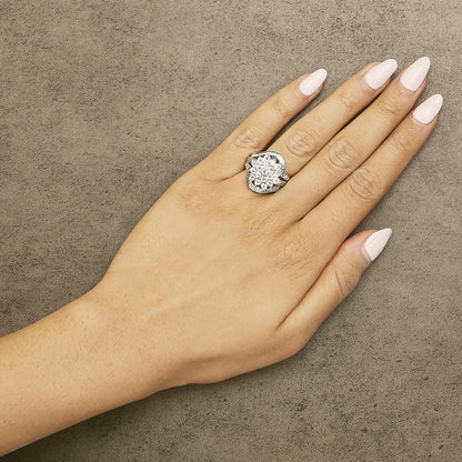 White metal ring with a cluster of round and baguette white gemstones, worn on a model's hand, shown from above at a slight angle.