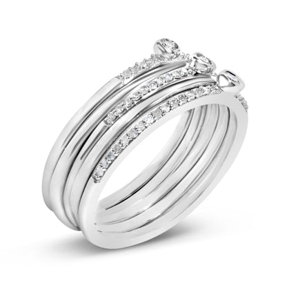 Close-up angled view of a white metal ring featuring five round white gemstones in bezel settings and multiple smaller round white gemstones in prong settings along the bands.