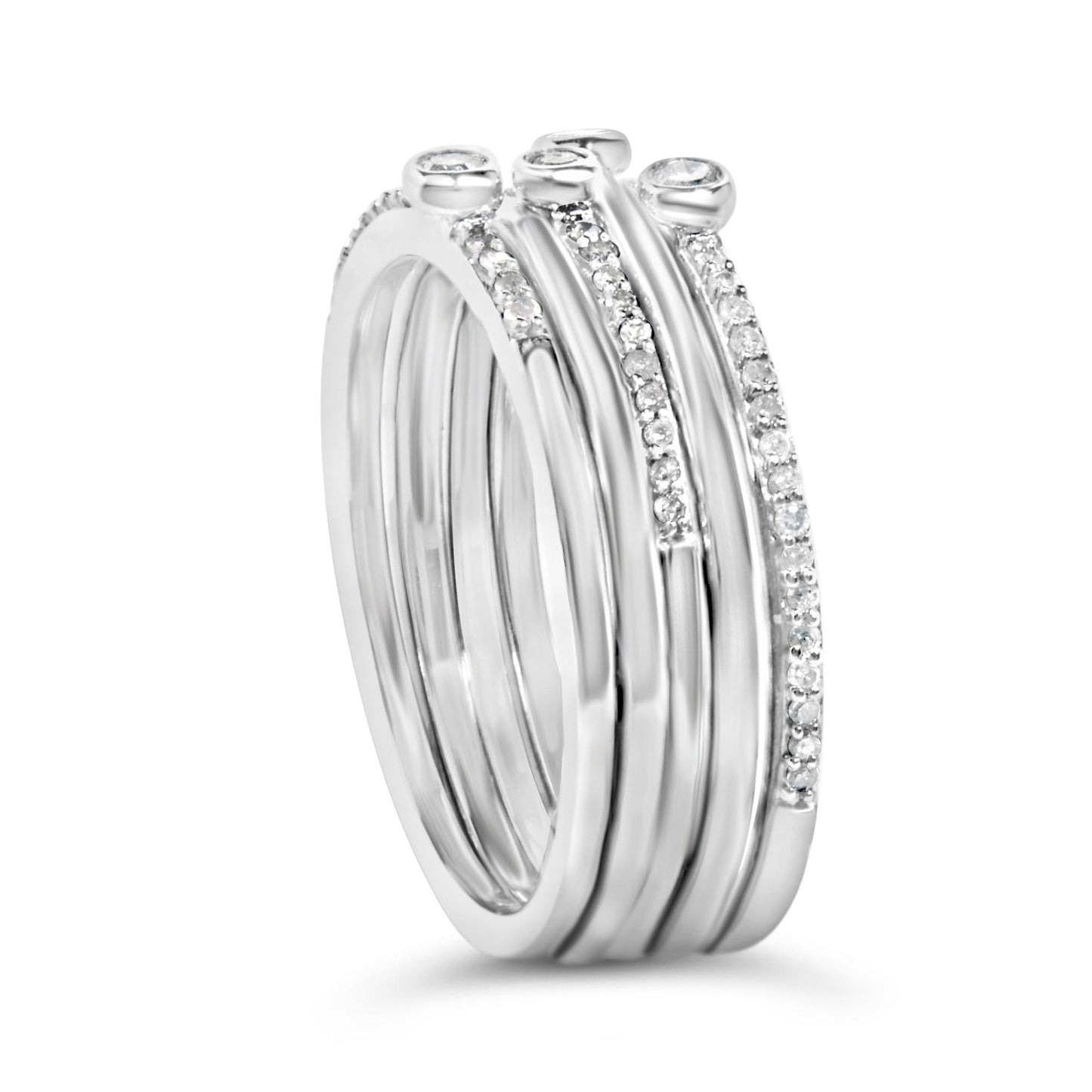 Close-up front angle of a set of four white metal stackable rings, three bands with small white gemstones in prong settings and two bands featuring larger white gemstones in bezel settings on top.