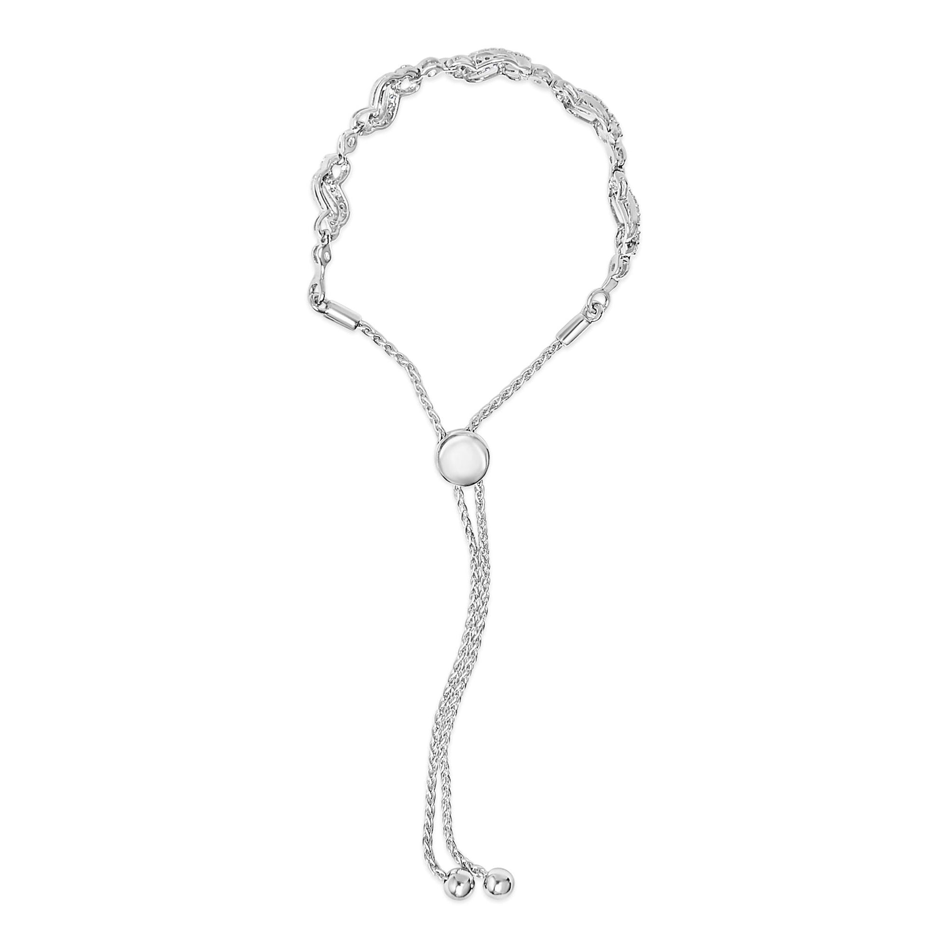 White metal bracelet with round white gemstones in prong settings on curved links, featuring an adjustable slider with two chain tassels, shown from the front on a white background.