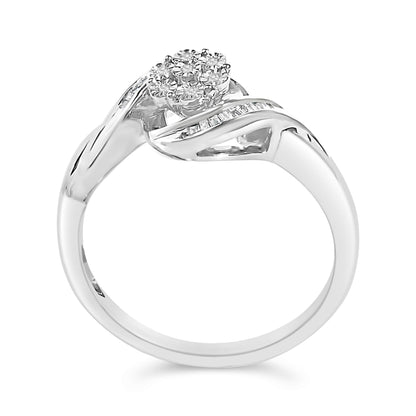 White metal ring shown at a slight angle, featuring a round cluster of white gemstones in prong setting on top, with two bands crossing and one band inset with white baguette-shaped gemstones in channel setting.