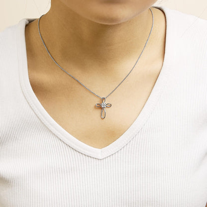Necklace shown worn on a model, featuring a white metal cross pendant with four round white gemstones in bezel settings, image taken from front angle.