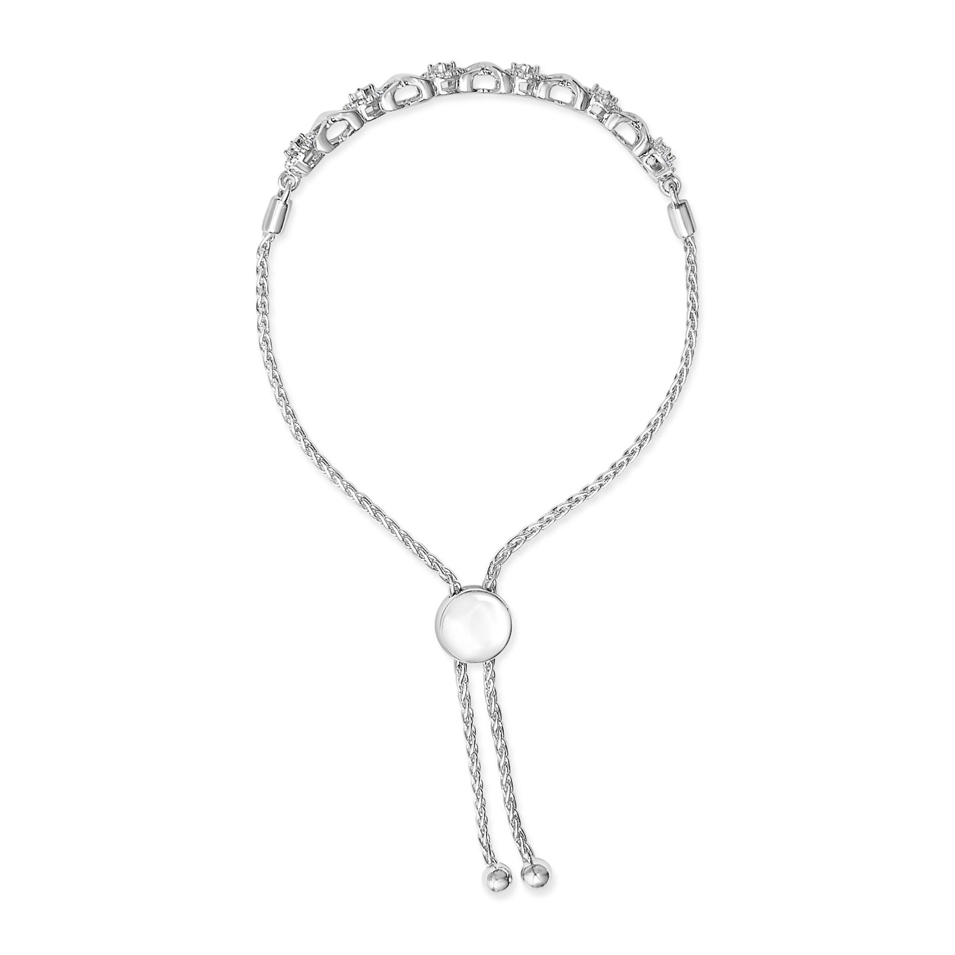 Front angled view of white metal bracelet with round prong-set white gemstones along the top, adjustable sliding clasp, and chain ends shown on a white background.